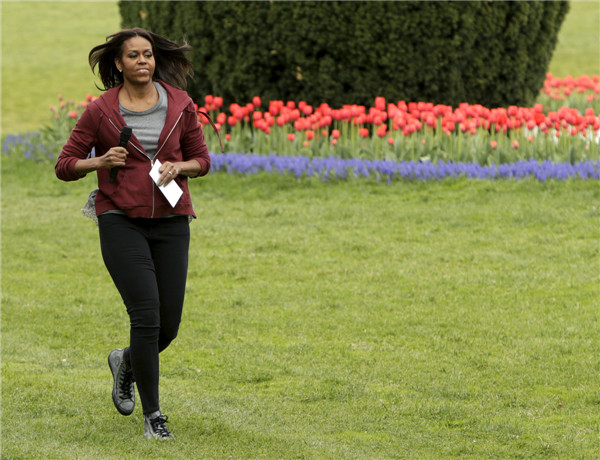 Michelle Obama plants vegetables with school children